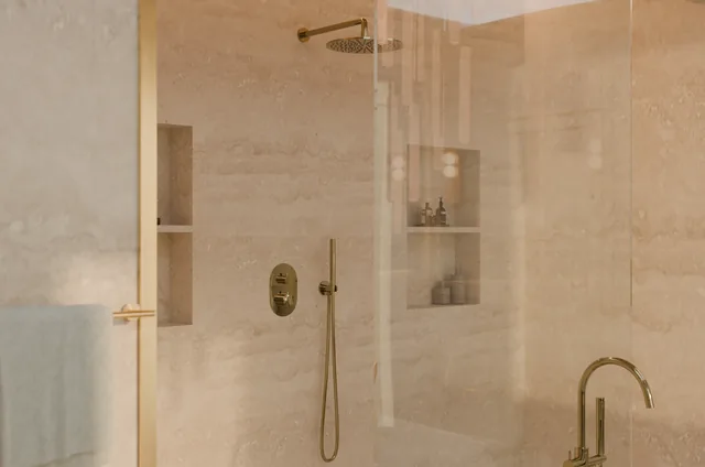 Warm stone shower with brass fittings and recessed shelving