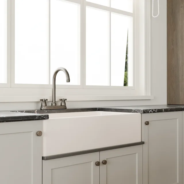 Belfast sink and dark stone worktop beneath a bright window